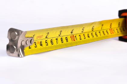 Mètre ruban jaune déployé pour mesurer une surface, loi Carrez